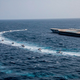 IRGC speedboats circling a mock aircraft carrier during exercises in a photo released on July 28, 2020. This photo was released by the IRGC and cannot be independently verified.